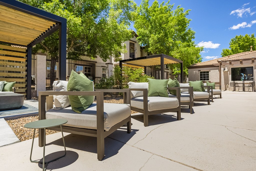 an outdoor patio with chairs and tables and a fire pit